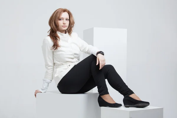Donna seduta su cubi bianchi — Foto Stock