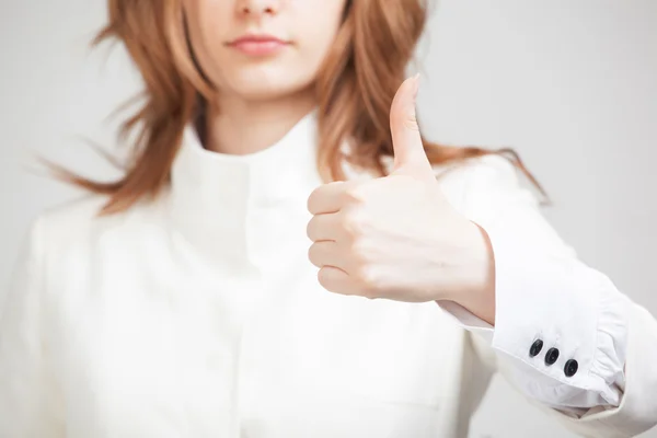 Vrouw in een witte jas verschijnt duim — Stockfoto