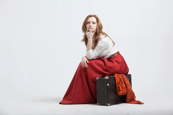 Kobieta siedzi na walizkę, na białym tle, tło białe — Zdjęcie stockowe