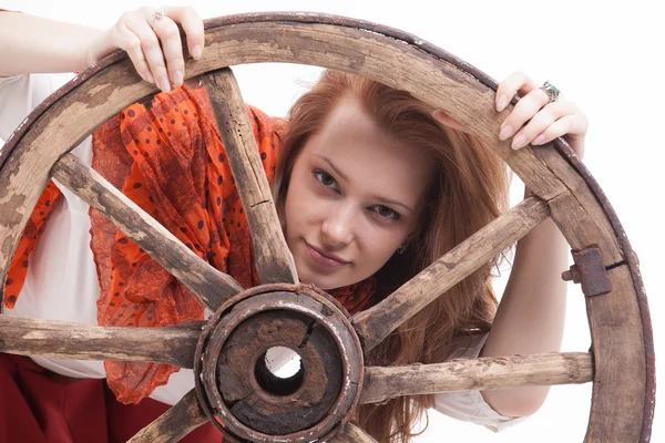 Giovane donna con una vecchia ruota del carro — Foto Stock