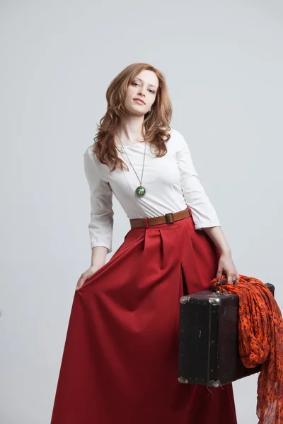 Kobieta w vintage czerwona spódnica z walizką — Zdjęcie stockowe