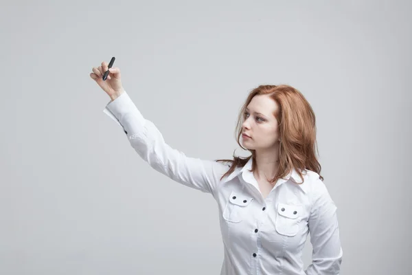 Young woman with pen on grey background — Stock Photo, Image