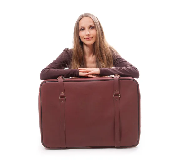 Fille assise près d'une valise, isolée sur blanc — Photo