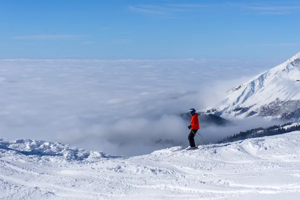 雲の上の山の頂上にスキーヤー — ストック写真