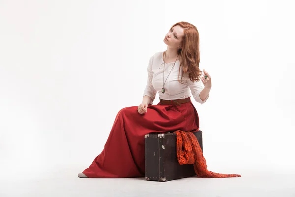 Woman sitting on suitcase, isolated, white background — Stock Photo, Image