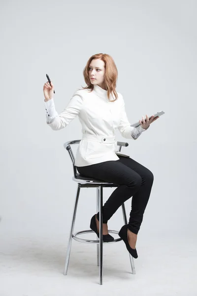 Young woman with pen on grey background — Stock Photo, Image