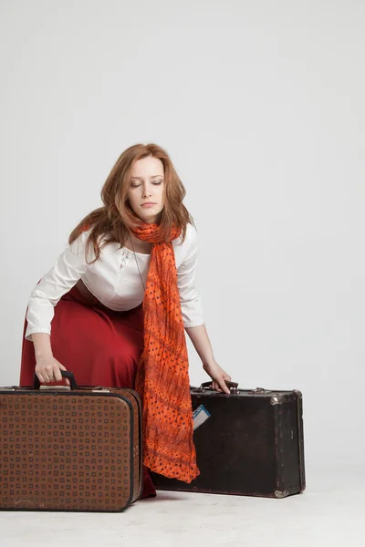 Женщина в винтажной красной юбке с чемоданами — стоковое фото