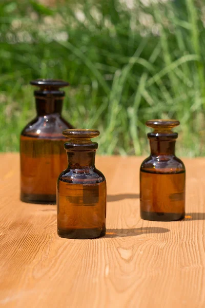 Kleine braune Flaschen auf Booden Board und Gras — Stockfoto