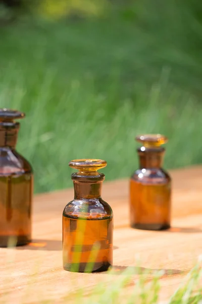 Pequeñas botellas marrones en booden tablero y hierba — Foto de Stock