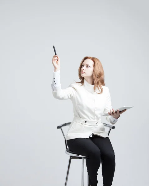 Young woman with pen on grey background — Stock Photo, Image