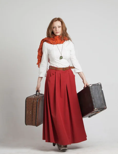 Donna in gonna rossa vintage con valigie — Foto Stock