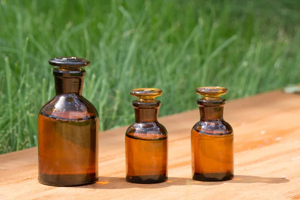 Kleine braune Flaschen auf Booden Board und Gras — Stockfoto