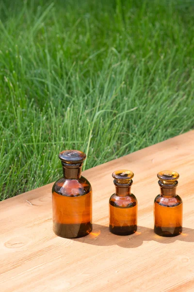 Kleine braune Flaschen auf Booden Board und Gras — Stockfoto