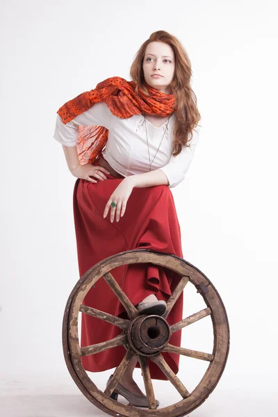 Uzun kırmızı etek ayakta yakınındaki tekerlek sepetinin kadında — Stok fotoğraf