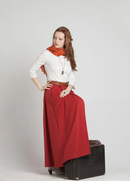 Donna in gonna rossa vintage con valigie — Foto Stock