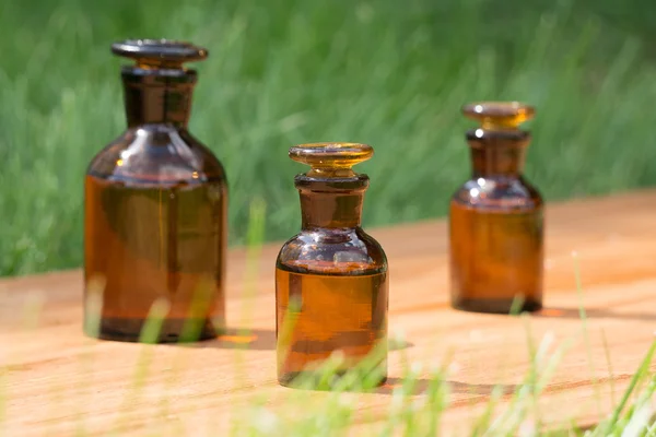 Pequeñas botellas marrones en booden tablero y hierba — Foto de Stock