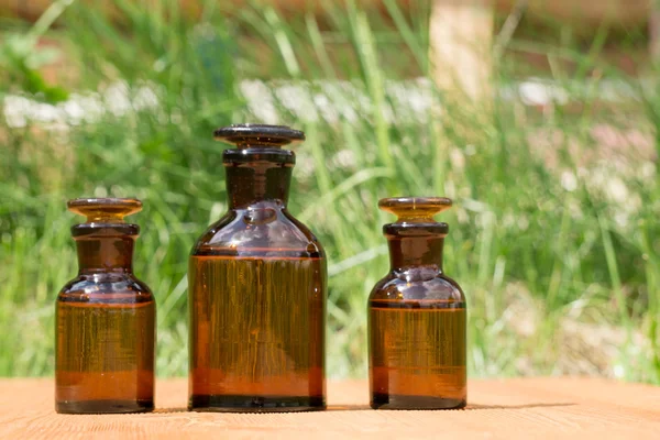 Pequeñas botellas marrones en booden tablero y hierba — Foto de Stock