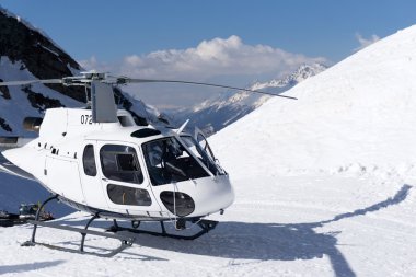 White rescue helicopter parked in the mountains clipart