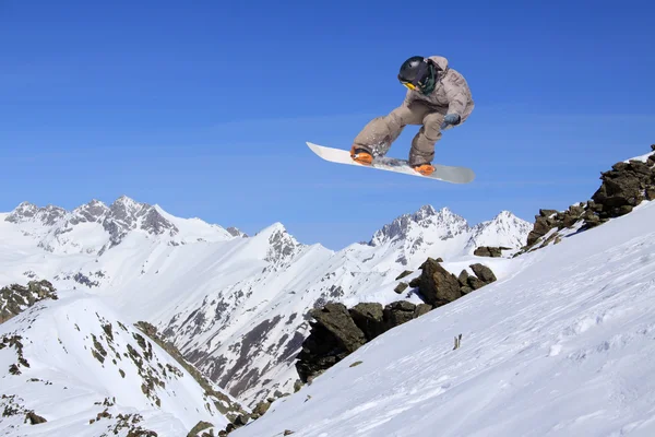 Flygande snowboardåkare på berg — Stockfoto