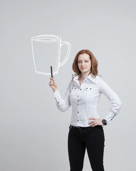Mladá žena čerpá šálek kávy na šedém pozadí — Stock fotografie
