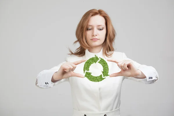 Mujer sosteniendo el símbolo de reciclaje en sus manos — Foto de Stock