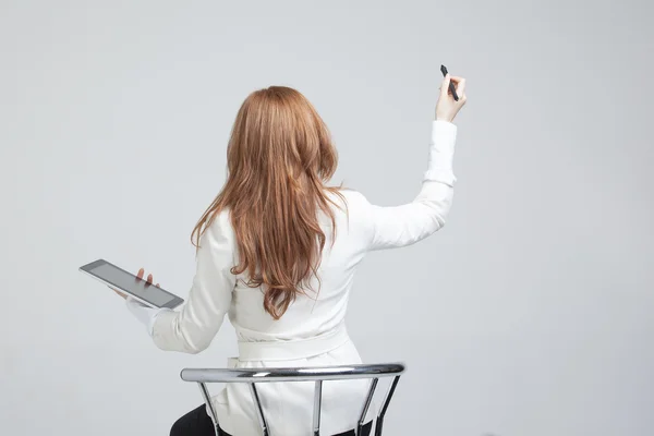 Jeune femme avec stylo sur fond gris — Photo