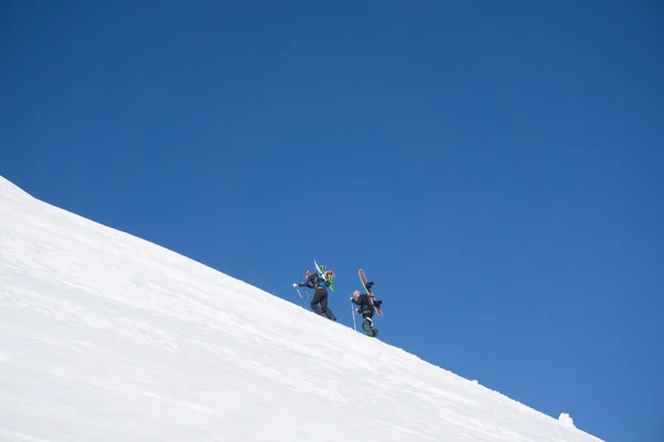 Snowboarders caminando cuesta arriba para freeride —  Fotos de Stock