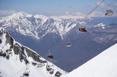 Kayakçı ve snowboard üzerinde bir teleferik