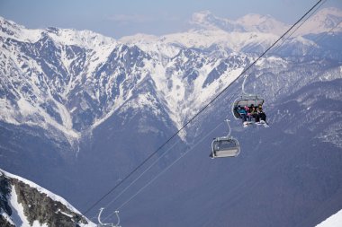 Kayakçı ve snowboard üzerinde bir teleferik
