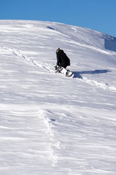 スノーボーダーが雪に覆われた山を登る — ストック写真