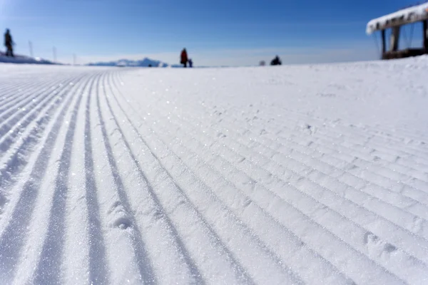 Trilhas de groomer de neve fresca em uma pista de esqui — Fotografia de Stock