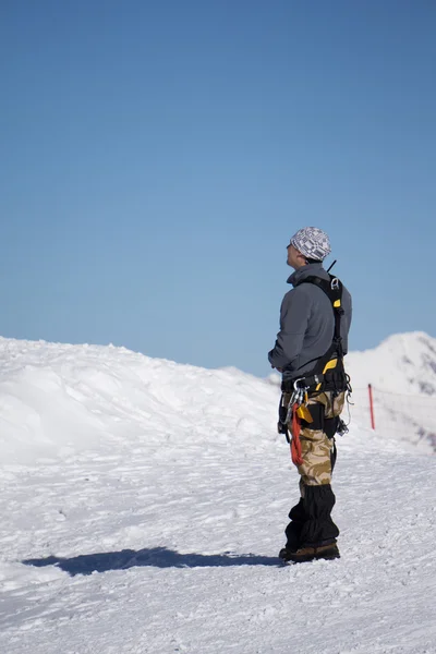 O alpinista está a olhar para a montanha coberta de neve — Fotografia de Stock