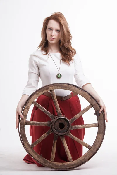 Young woman with an old wagon wheel — Stock Photo, Image