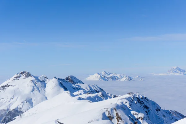 Vista sobre montanhas e céu azul acima das nuvens — Fotografia de Stock