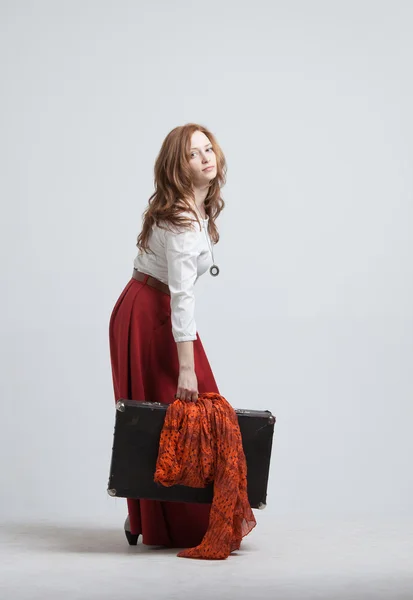 Femme en jupe rouge vintage avec une valise — Photo
