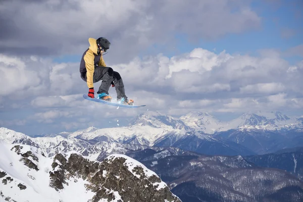 Flygande snowboardåkare på berg — Stockfoto