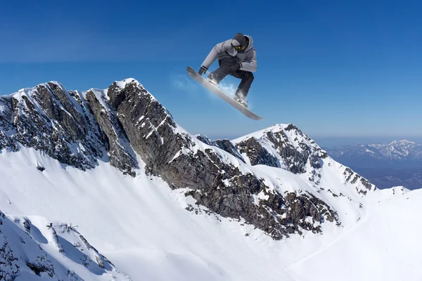 Flygande snowboardåkare på berg — Stockfoto