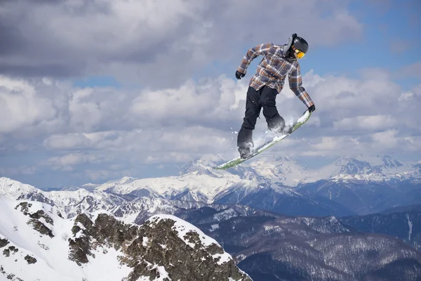 Flying snowboarder on mountains