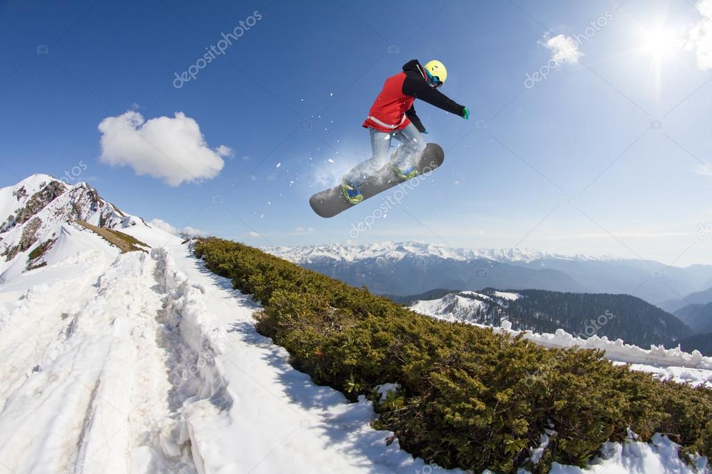 Flying snowboarder on mountains