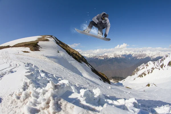 Dağlar üzerinde uçan snowboarder — Stok fotoğraf