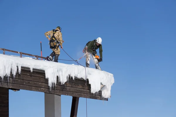 Sotschi, Russland - 22. Januar 2015: Industriekletterer hebt Schnee und Eiszapfen vom Dach — Stockfoto