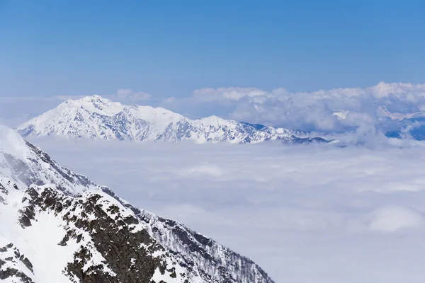 Visa på bergen och blå himmel ovanför molnen, Krasnaya Polyana, Sochi, Ryssland — Stockfoto