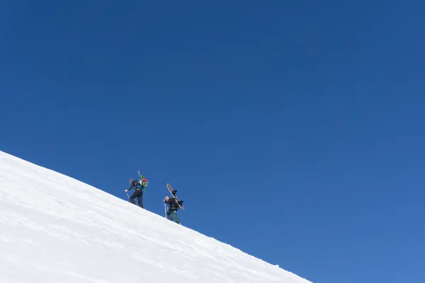 フリーライドの上り坂を歩いてスノーボーダー — ストック写真