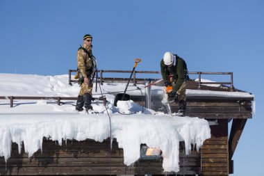 Sochi, Rusya Federasyonu - 22 Ocak 2015: kar ve buz sarkıtları çatıdan endüstriyel dağcılar çıkar