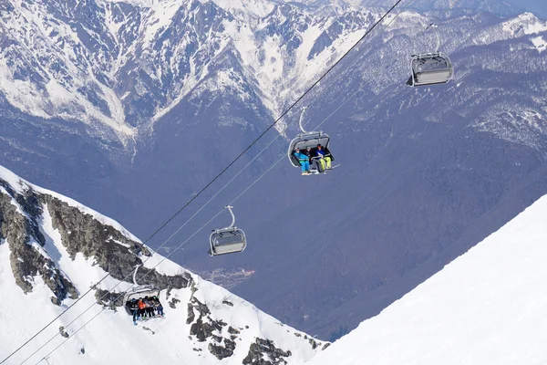 Esquiadores y snowboarders en un telesilla —  Fotos de Stock