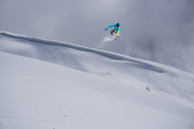 dağlar üzerinde uçan snowboarder