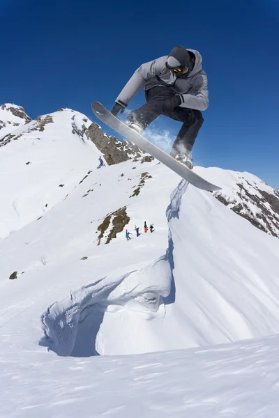 Snowboarder voador em montanhas — Fotografia de Stock