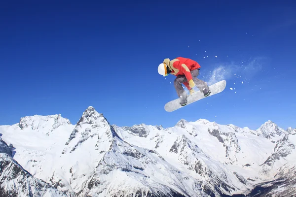Flygande snowboardåkare på berg — Stockfoto