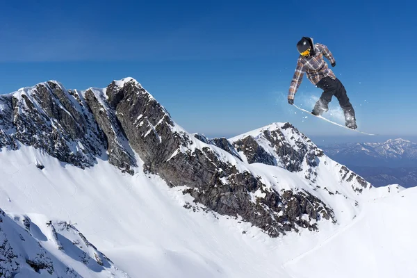 Flygande snowboardåkare på berg — Stockfoto