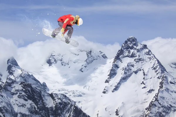 Dağlar, aşırı spor üzerinde uçan snowboarder — Stok fotoğraf